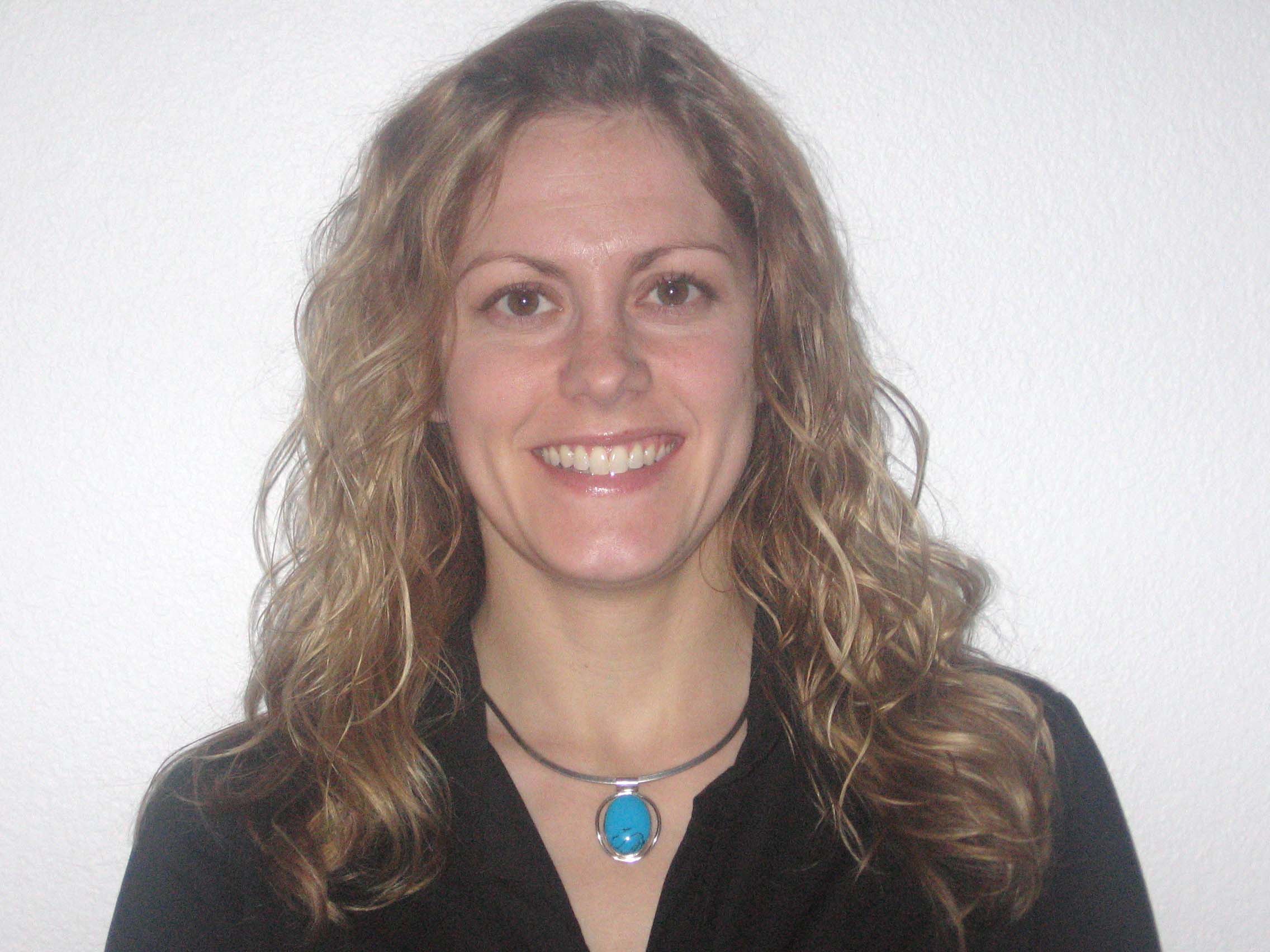 Bio portrait of Dr. Elise Gingrich smiling, in a black shirt in front of a white background